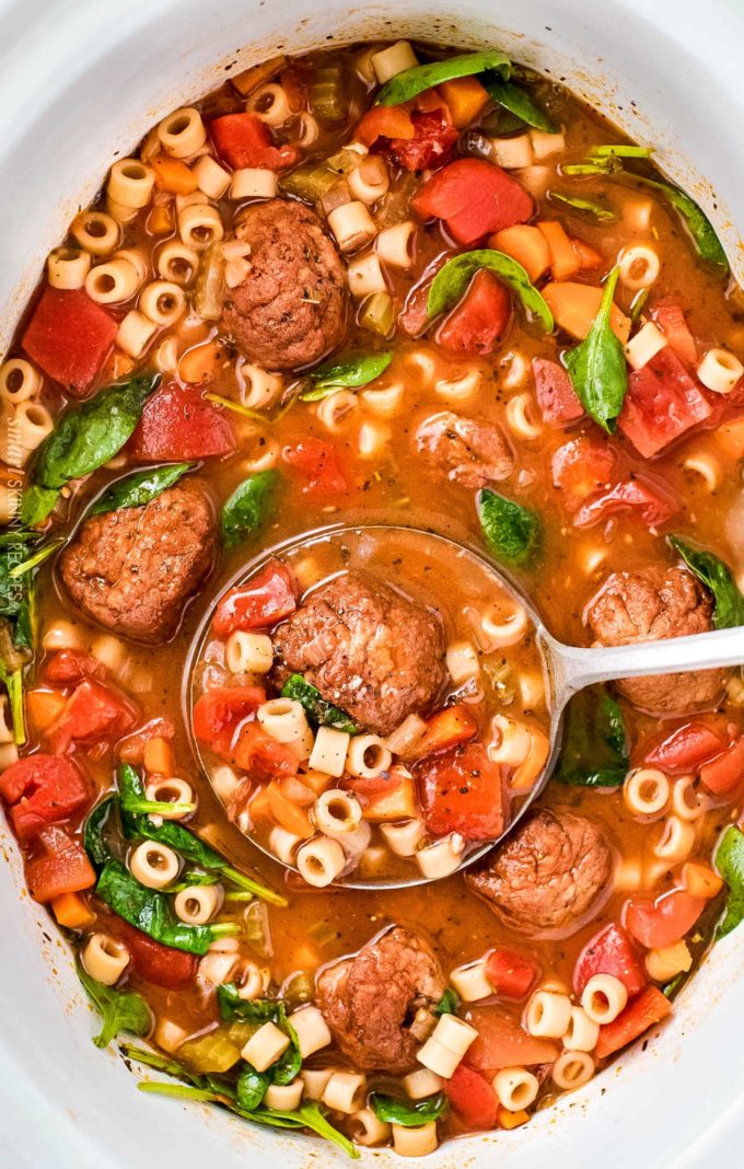 Ladle of Italian meatball soup in slow cooker