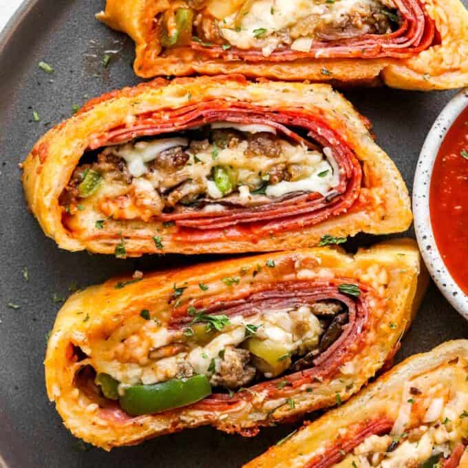 https://www.thechunkychef.com/wp-content/uploads/2021/08/Sliced-stromboli-on-plate-with-sauce-680x679.jpg