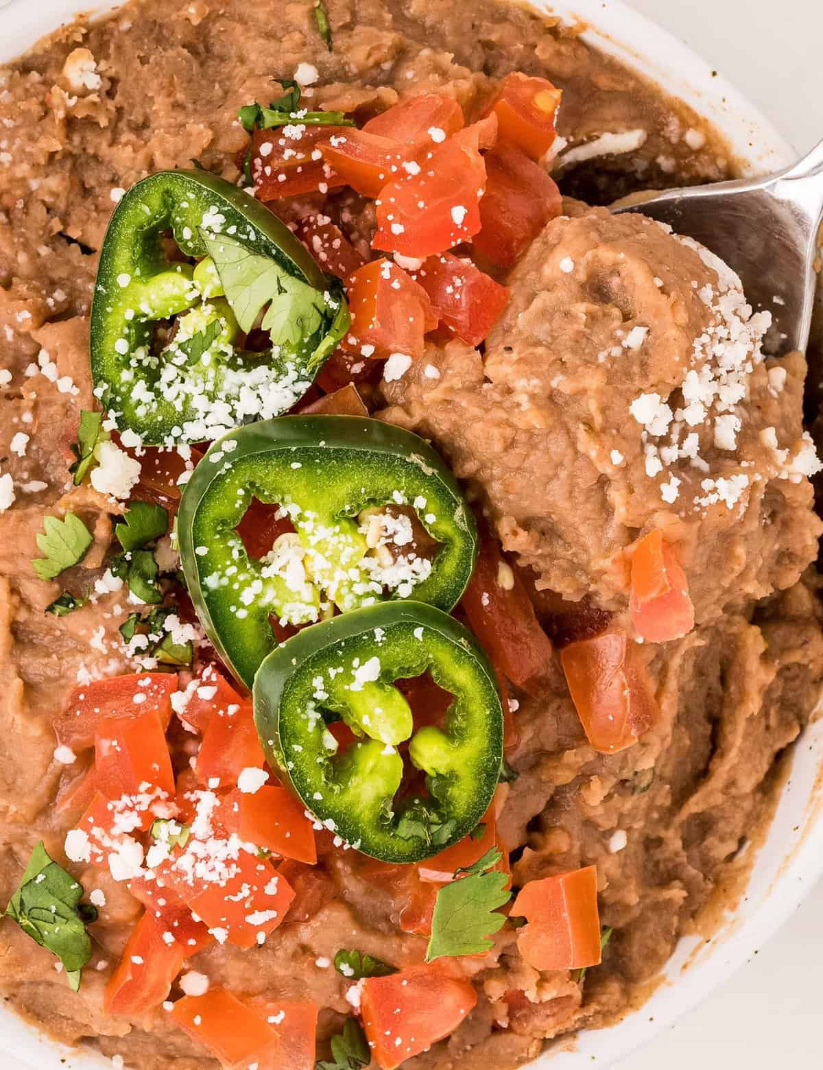 These Instant Pot Refried Beans are so full of flavor and easy to make, with no soaking required! Tastes way better than canned, and every bit as delicious as the beans from your local Mexican restaurant!