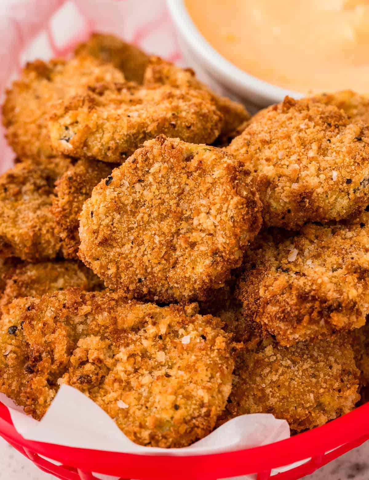 These "fried" pickles are the ultimate party food! Made with simple ingredients like dill pickles, flour, eggs, seasonings and breadcrumbs, this appetizer recipe is made easily in the air fryer (oven directions too)!