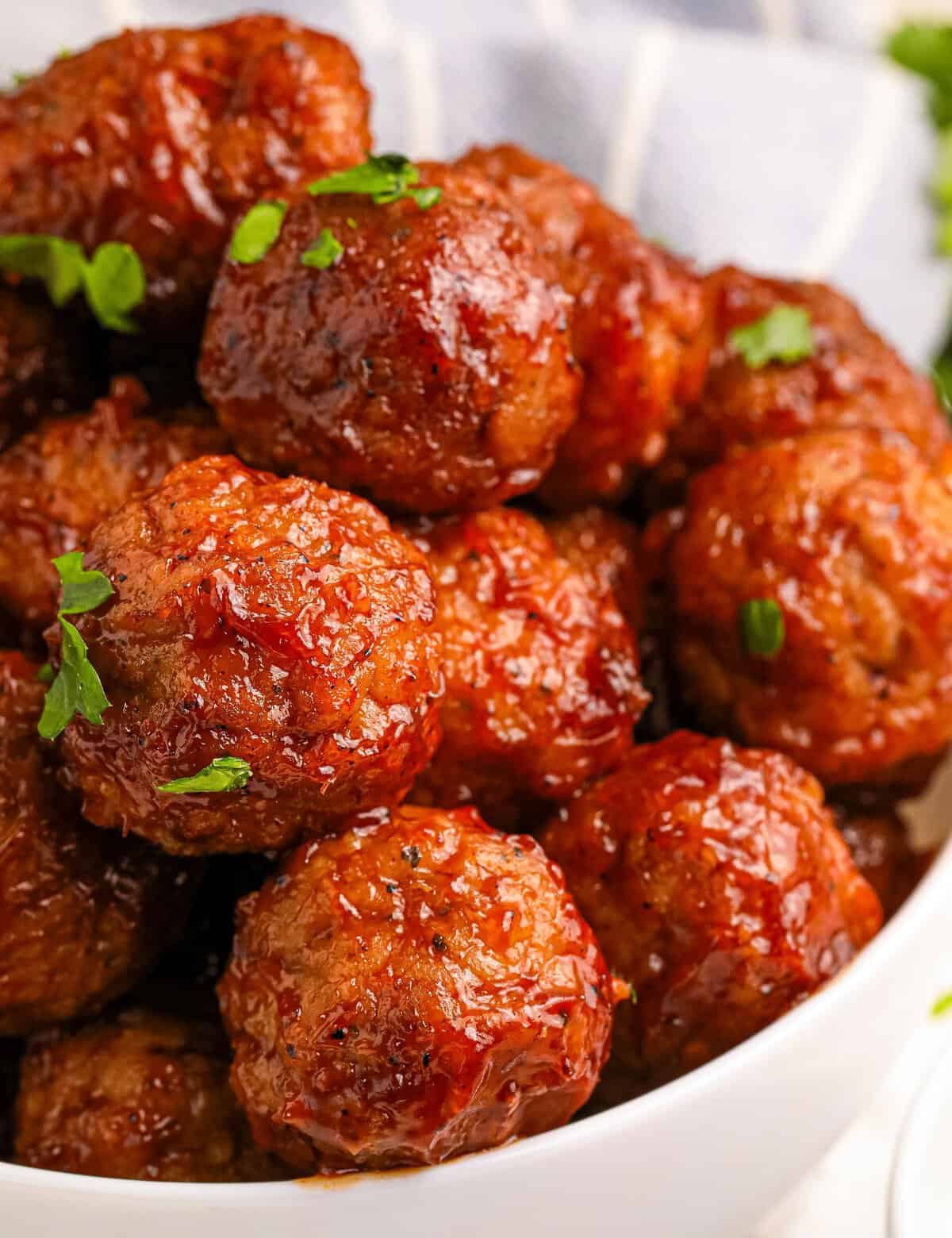 These Raspberry Balsamic Crockpot Meatballs are made easily with frozen meatballs and cooked low and slow in a mouthwatering sweet and savory sauce made from just 5 ingredients! Perfect as a party appetizer, game day treat, or fun dinner!