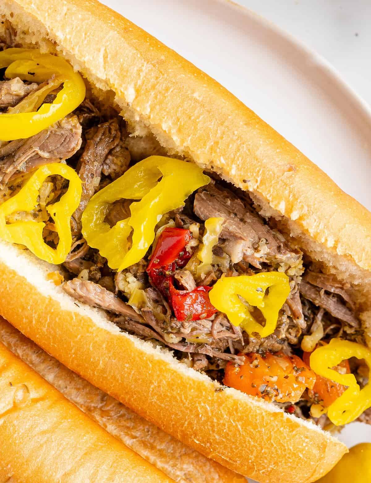 Deliciously tangy and piquant, this slow cooker Italian beef is made easily with simple ingredients and cooks all day, so it's ready when you get home! Perfect on sandwiches, sliders, or over mashed potatoes, this recipe is pure comfort food.