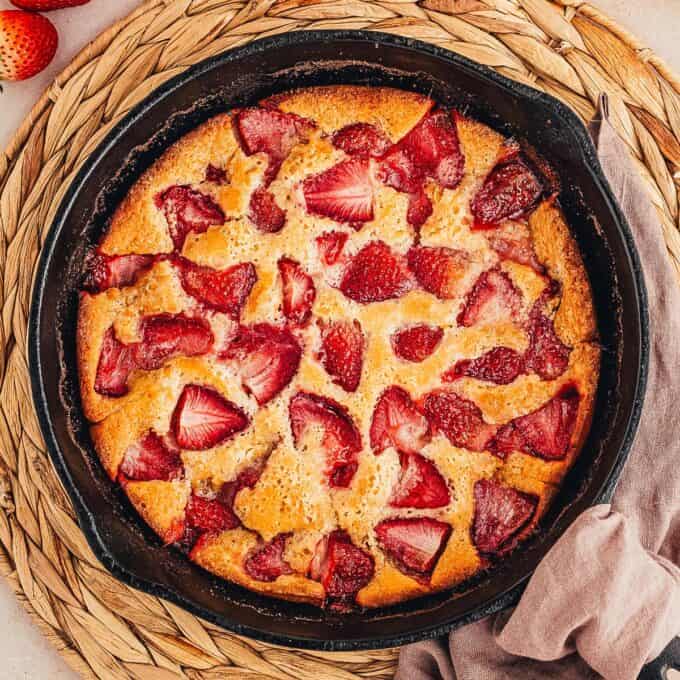overhead photo of strawberry cobbler in a cast iron skillet.