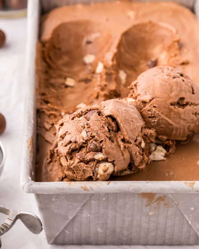 two scoops of chocolate ice cream with malted milk balls.
