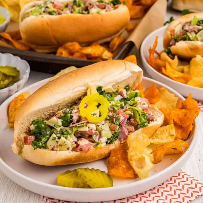 plates with chips and a chopped salad sandwich.