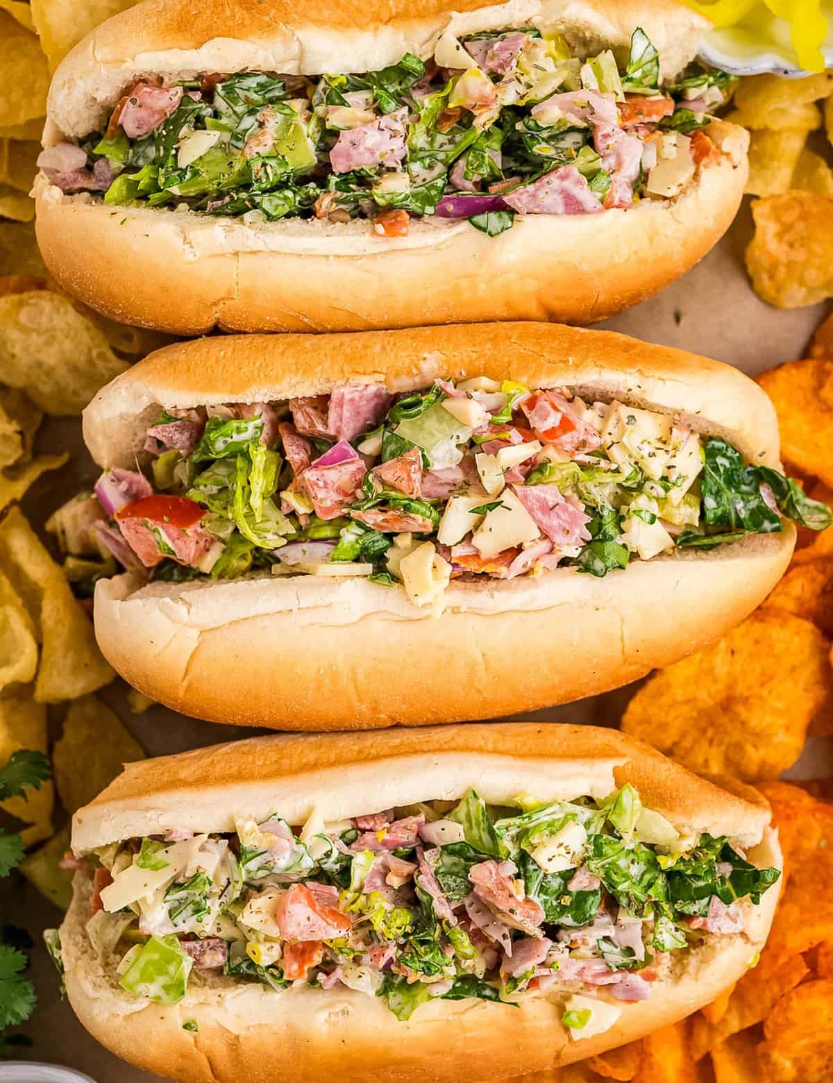 A fresh and delicious chopped salad, complete with several meats, cheeses, and vegetables, tossed with a zippy creamy Italian dressing, and served in soft hoagie rolls. Such a fun way to enjoy a salad!