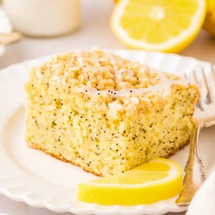 white scalloped plate topped with a slice of lemon poppyseed coffee cake.