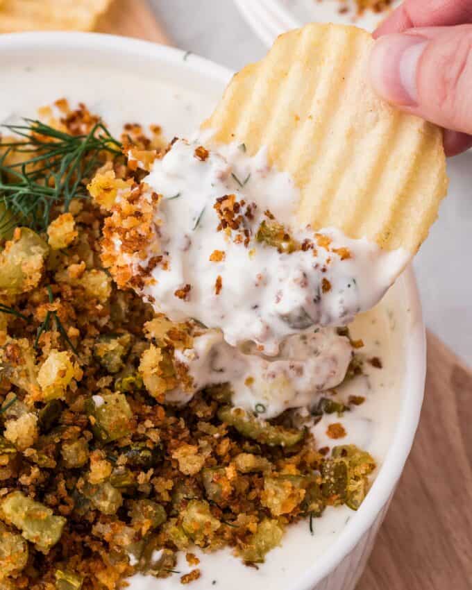 dipping a potato chip into fried pickle dip