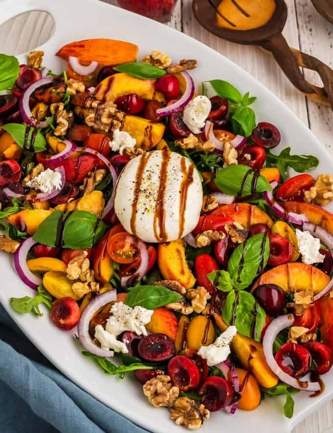 This summer peach burrata salad is great for using all of the amazing fresh produce that's in season, and is such a flavor explosion! The creaminess of the fresh burrata cheese combines effortlessly with the peaches, cherries, tomatoes, onions and more, and the sweet and tart balsamic glaze is the perfect dressing. Great for a light lunch or dinner!