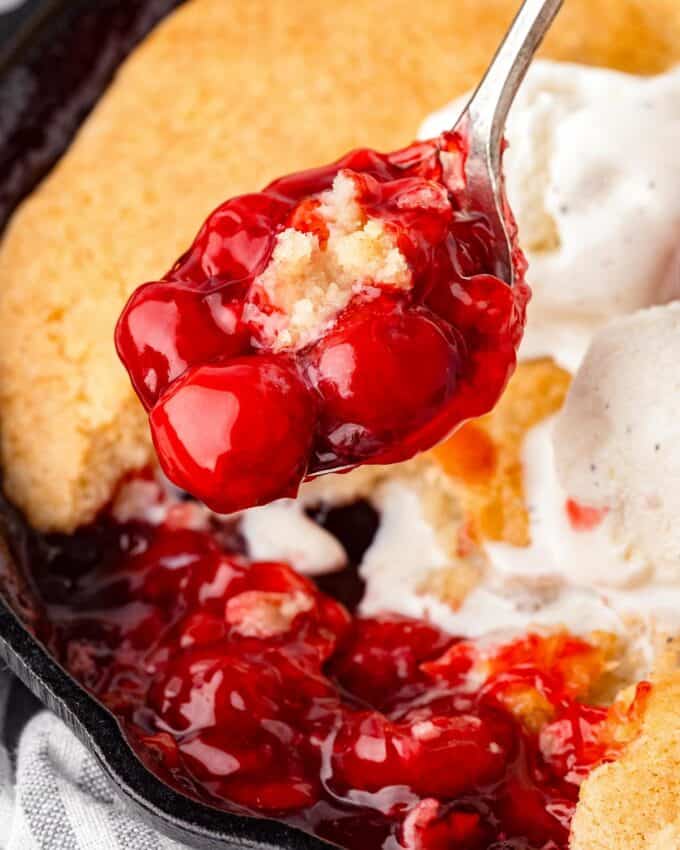 serving spoon of cherry cobbler.