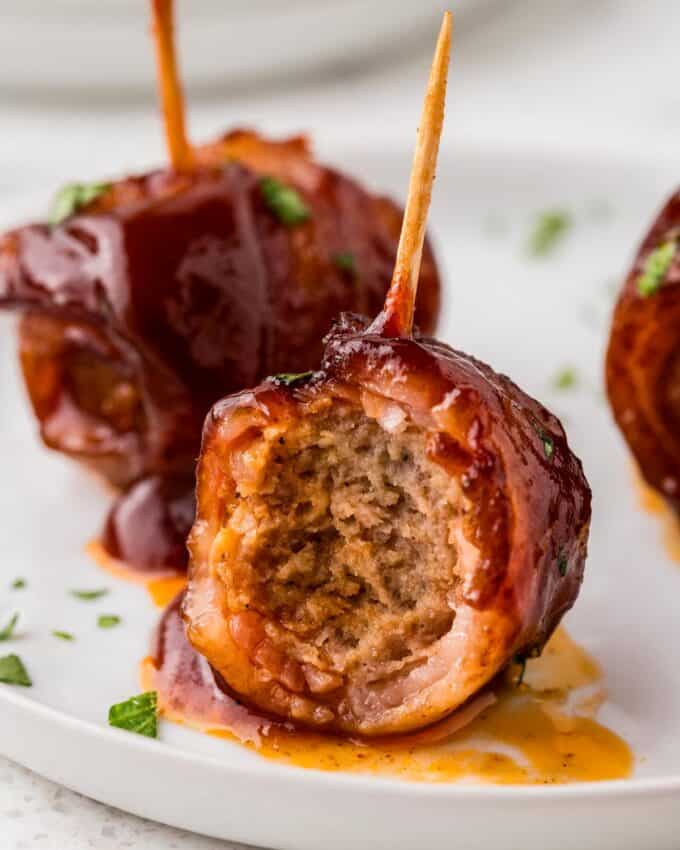 bacon brown sugar meatball with a bite taken out of it.