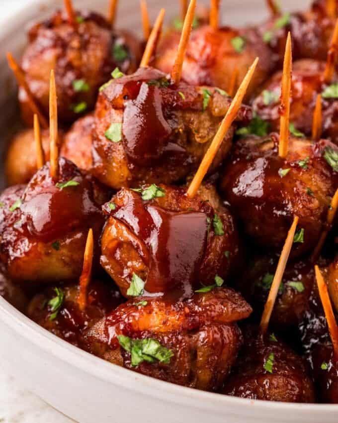 bacon wrapped slow cooker meatballs drizzled with bbq sauce.