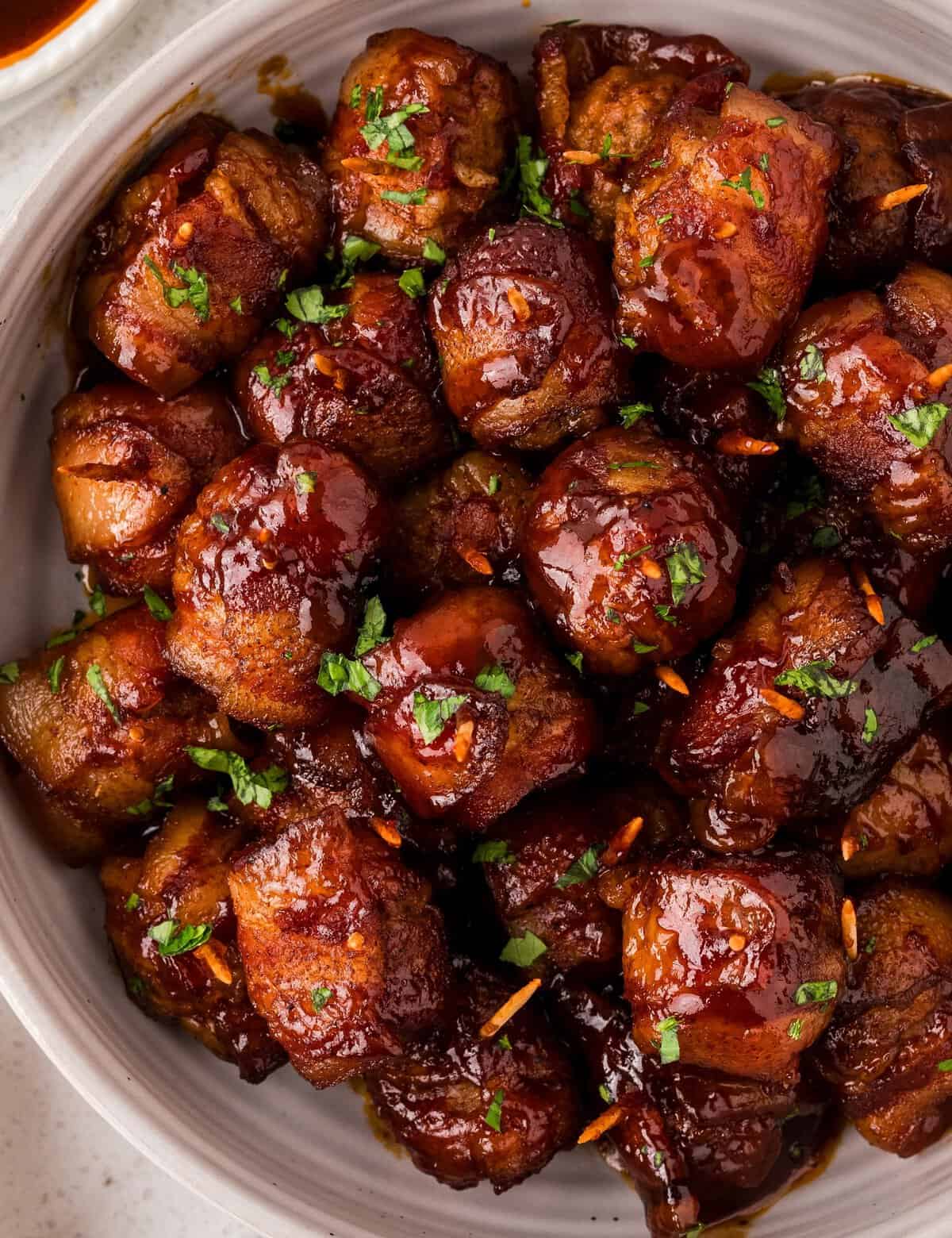 These bacon-wrapped brown sugar bbq meatballs are perfect for any party, and so easy to make! Frozen meatballs are thawed, wrapped in smoky bacon, coated in a spiced brown sugar mixture, tossed with bbq sauce and slow cooked to perfection. Plus, this recipe only has 5 ingredients!