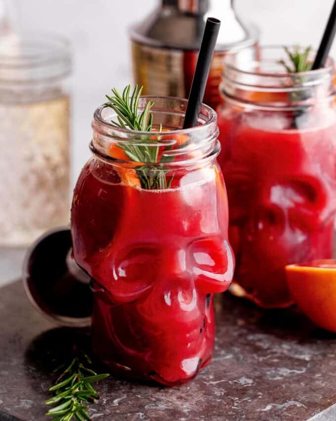 blood orange whiskey cocktail recipe served in skull glasses for Halloween.