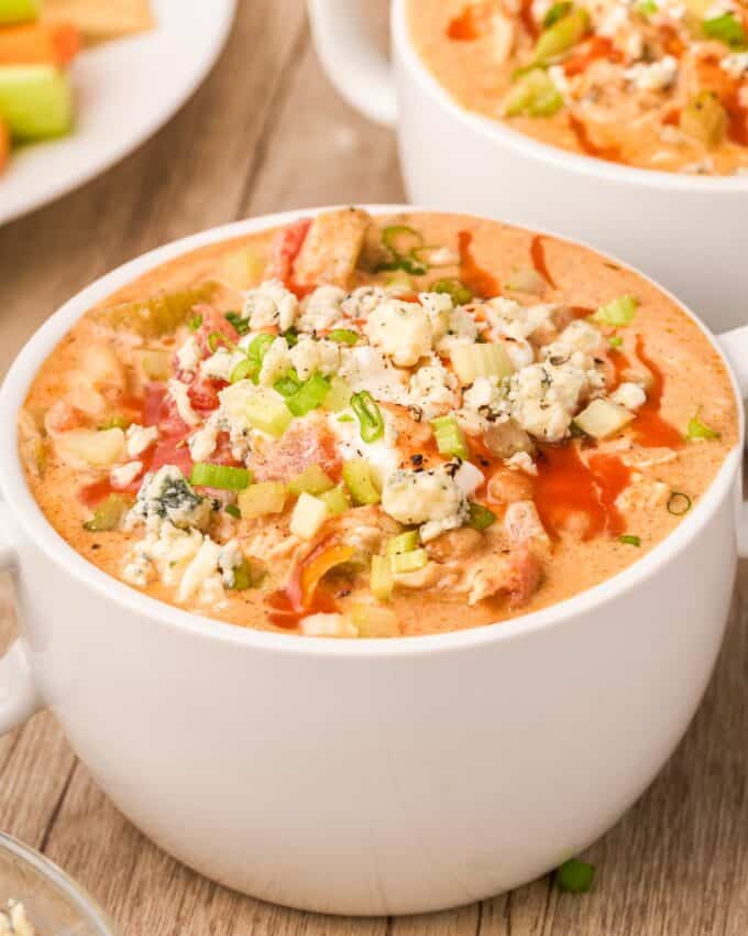 white mug of buffalo chicken chili with all the toppings.