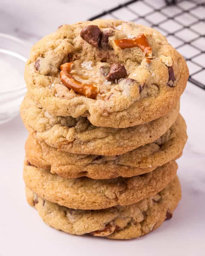 stack of cookies with chocolate chips, pretzels, caramel, and sea salt.