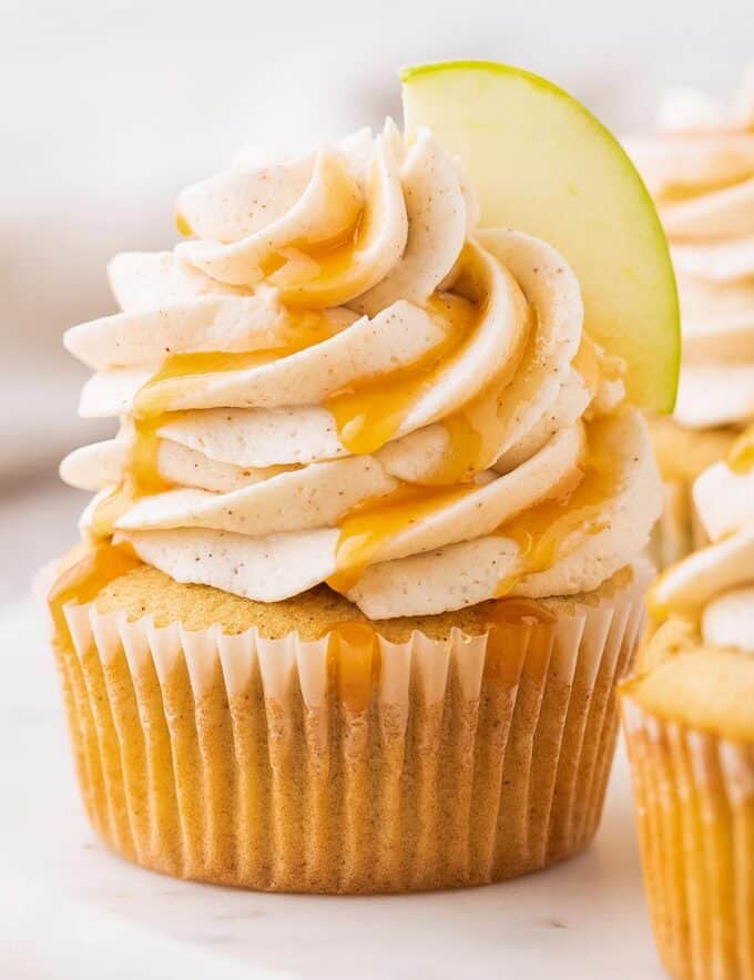 These caramel apple cupcakes are the perfect blend of fluffy, soft, and moist. Studded with diced apples and topped with a generous swirl of caramel cinnamon buttercream frosting, they taste like a sweet caramel apple, and are perfect for the Fall season!