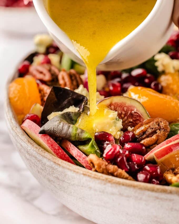 Drizzling apple cider vinaigrette over a harvest salad.