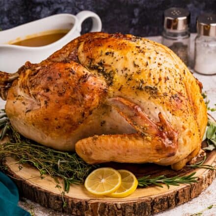 roasted turkey on cutting board with herbs