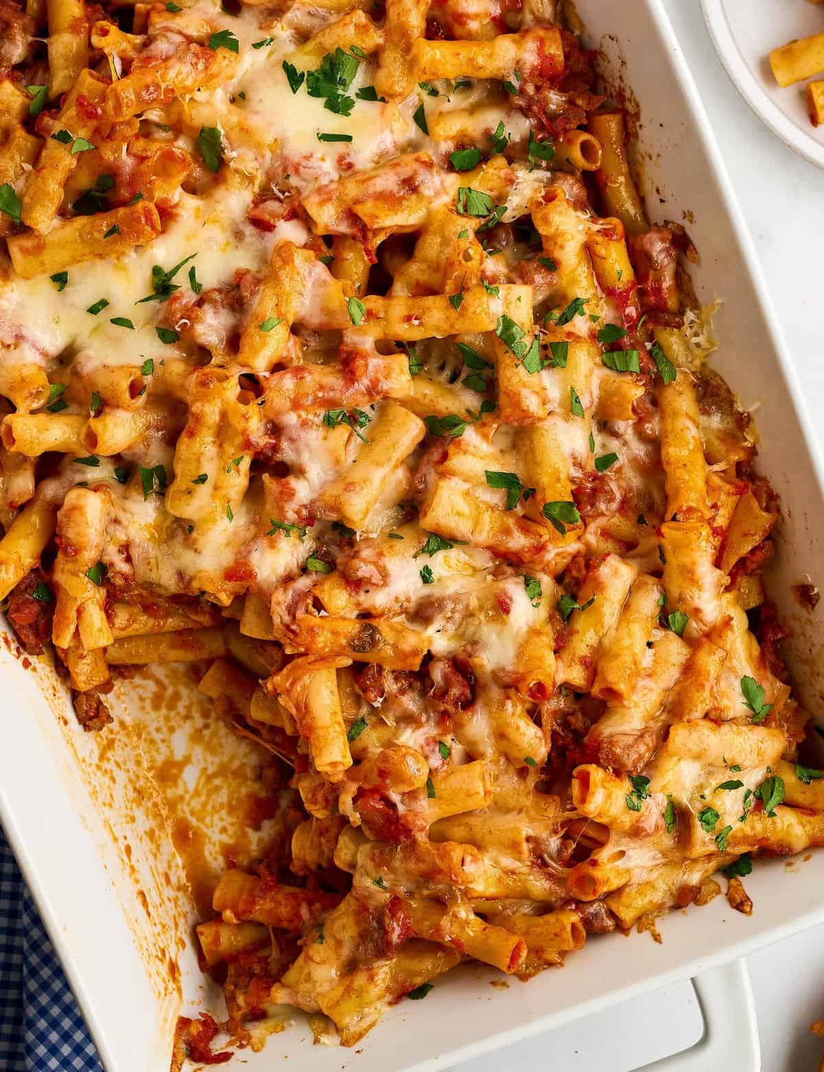 This baked ziti recipe is loaded with sausage and cheesy deliciousness! Perfect as a freezer meal or a big family dinner, this baked pasta dish is made with al dente pasta, a marinara meat sauce, and plenty of mozzarella and pecorino romano cheese!