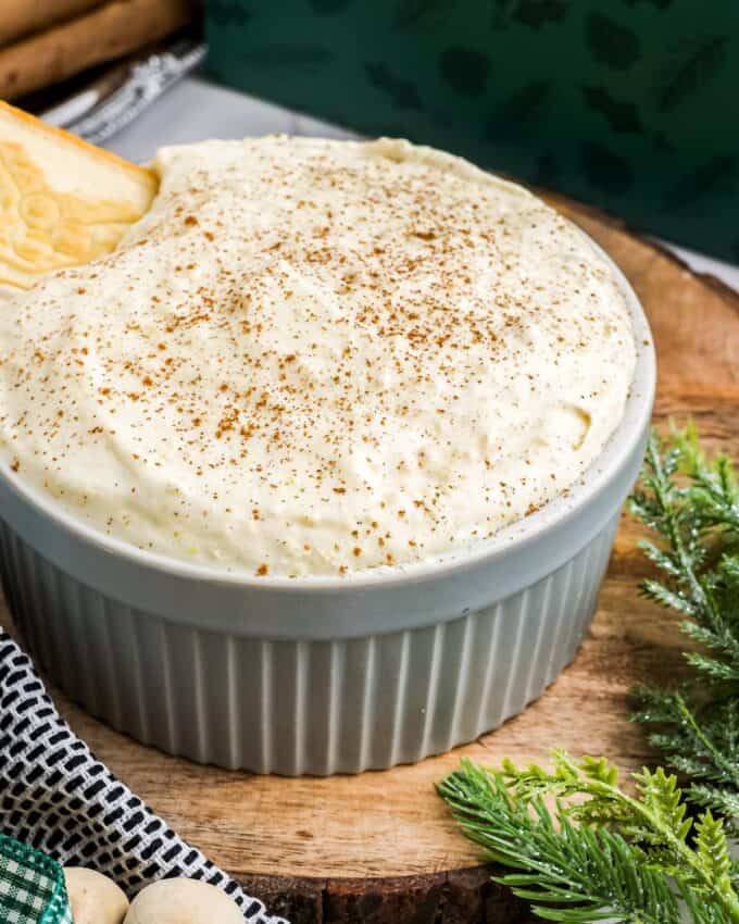 serving bowl of eggnog dip on wooden platter