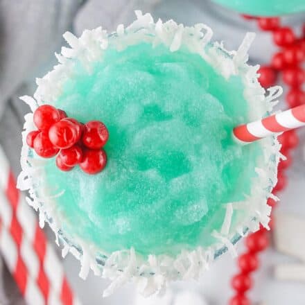 overhead photo of the top of a jack frost cocktail garnished with a flaked coconut rim and holly sprig.