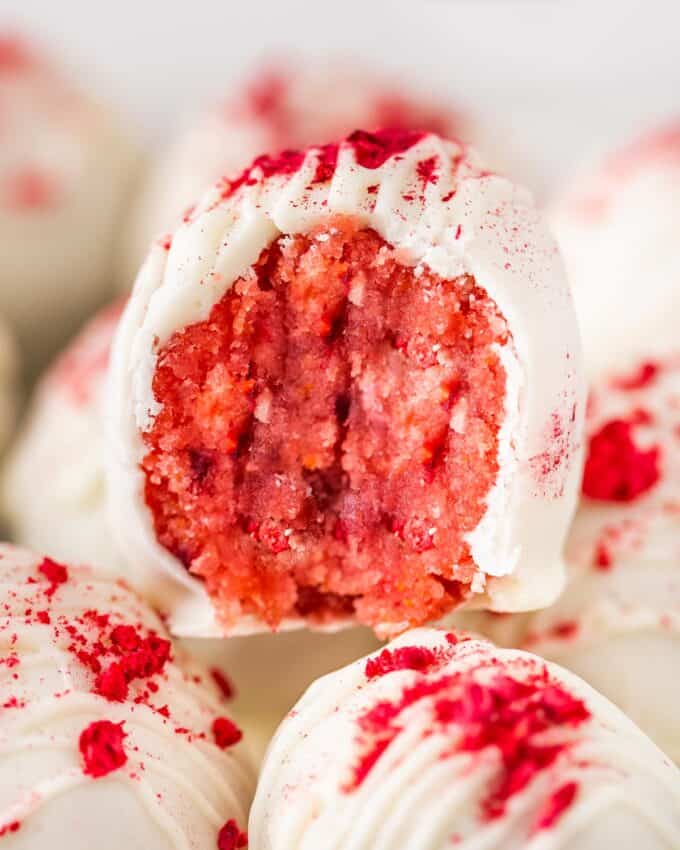 raspberry cake ball with a bite taken out of it