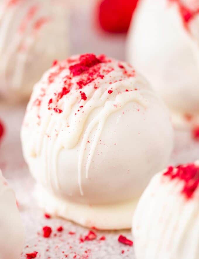 These raspberry white chocolate cake balls are full of sweet raspberry flavor, coated in a white chocolate coating, and sprinkled with crushed freeze-dried raspberries! Perfect for an easy no-bake treat, these are just like cake pops (just without the stick), and a favorite among people of all ages!