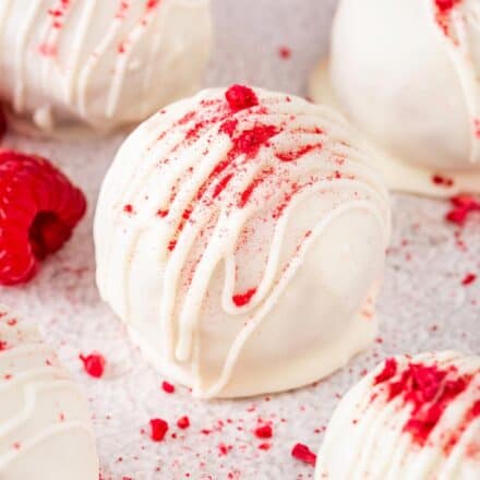 raspberry white chocolate cake balls sprinkled with raspberry powder