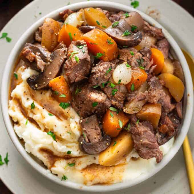 overhead bowl of mashed potatoes topped with beef bourguignon