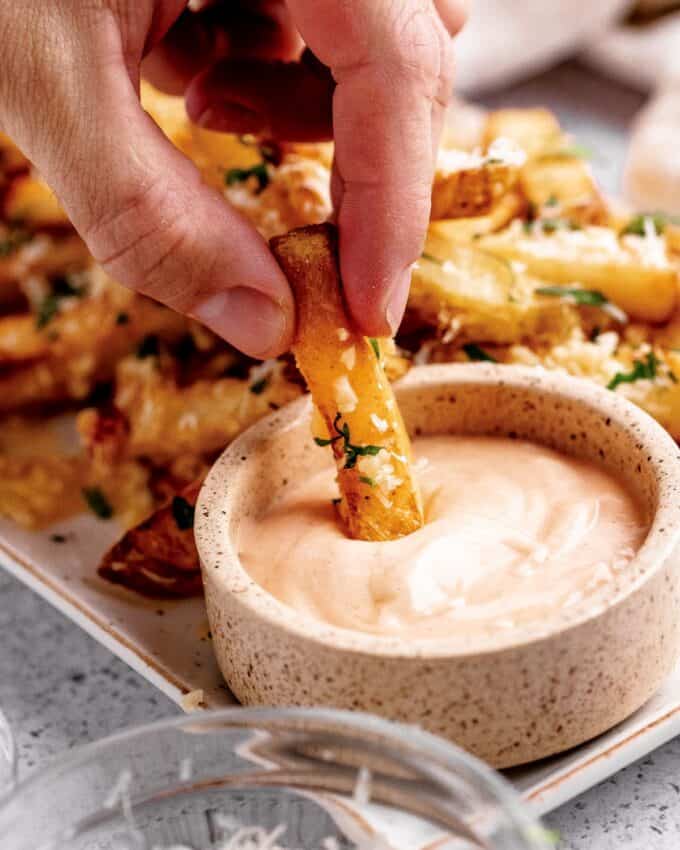 dipping a french fry into dipping sauce