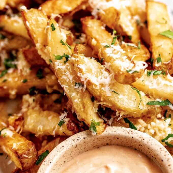 pile of air fryer french fries with a dipping sauce.