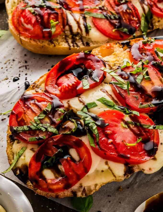 Caprese garlic bread is so simple to make! It all starts with a loaf of bakery bread that's spread with an easy homemade garlic and herb butter, then topped with fresh mozzarella, sliced tomatoes, fresh basil, and a drizzle of balsamic glaze. Perfect as a side dish, or serve with a salad or veggie to make a light meal!