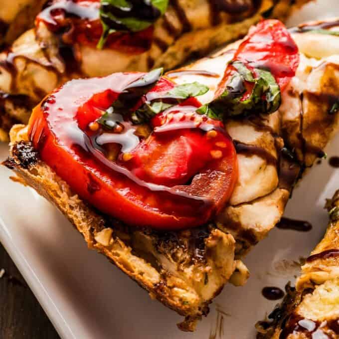 slice of caprese garlic bread drizzled with balsamic glaze