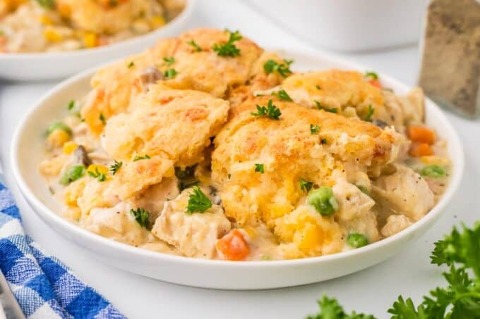 This creamy and hearty chicken cobbler is everything you love about rich chicken pot pie, but instead of a finicky pie crust, it's baked in a casserole dish and topped with cheddar and garlic biscuits! So easy to customize to your family's tastes, and on the table in about 45 minutes!