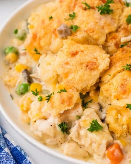 This creamy and hearty chicken cobbler is everything you love about rich chicken pot pie, but instead of a finicky pie crust, it's baked in a casserole dish and topped with cheddar and garlic biscuits! So easy to customize to your family's tastes, and on the table in about 45 minutes!