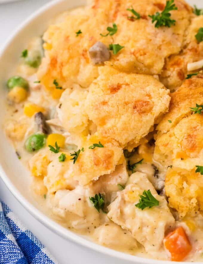 This creamy and hearty chicken cobbler is everything you love about rich chicken pot pie, but instead of a finicky pie crust, it's baked in a casserole dish and topped with cheddar and garlic biscuits! So easy to customize to your family's tastes, and on the table in about 45 minutes!