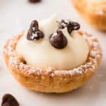 close up photo of a mini cannoli cup dusted with powdered sugar.